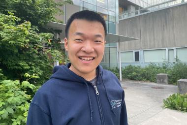 开云体育最新网站UBC计算机工程专业的学生Fisher Xue对着镜头微笑。他的中心是他身后的一座建筑和绿色植物。