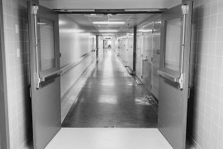 一张黑白照片，上面是一条狭长的空荡荡的医院走廊